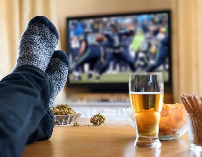 Television, TV watching (football match) with feet on table and huge amounts of snacks